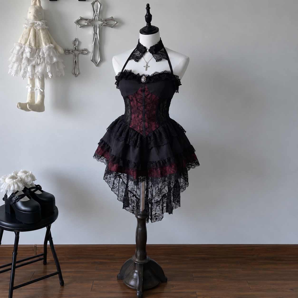 Black and burgundy lace-up dress on a mannequin, showing layered skirt and long lace back hem