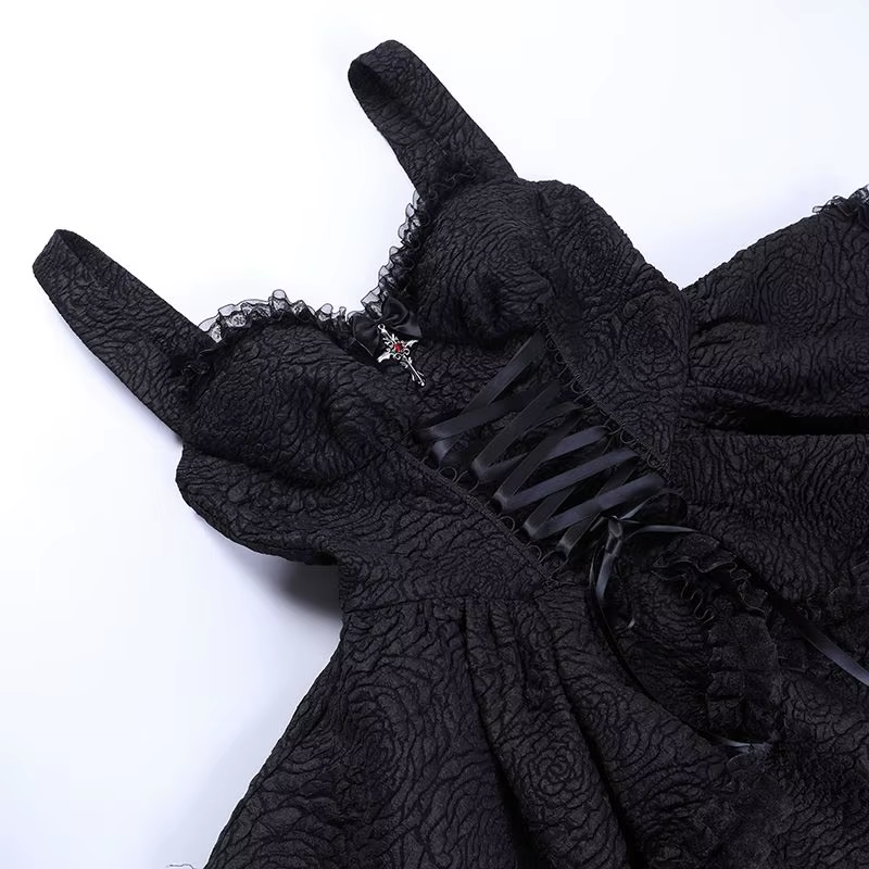 Black mini dress laid flat, showing the wide straps, lace-trim neckline and ribbon-laced bodice.